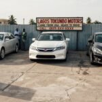 Toyota Camry, Honda Accord, and Nissan Altima parked side by side at a Nigerian car lot